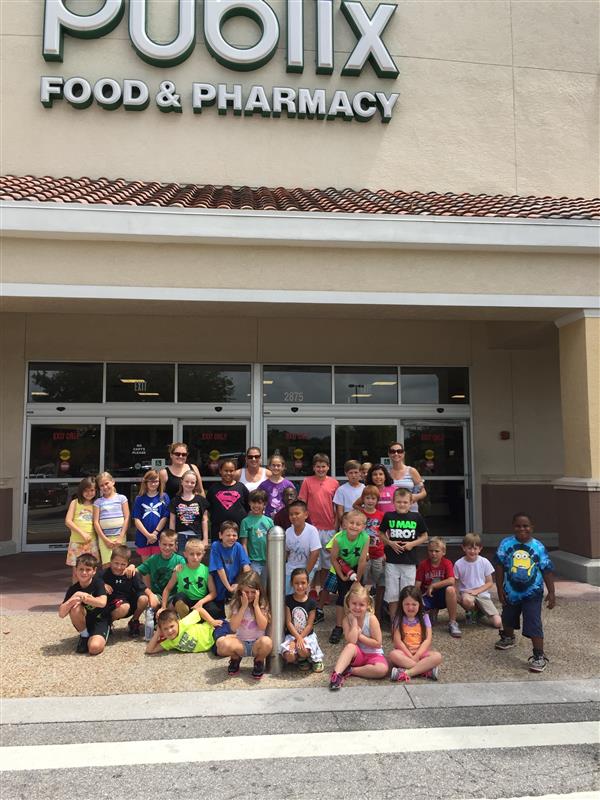 students pose in front of Publix supermarket